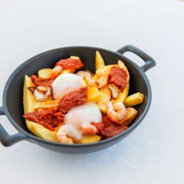 Garlic prawns over crispy potatoes, slow-cooked eggs and grilled sobrasada (Majorcan sausage)