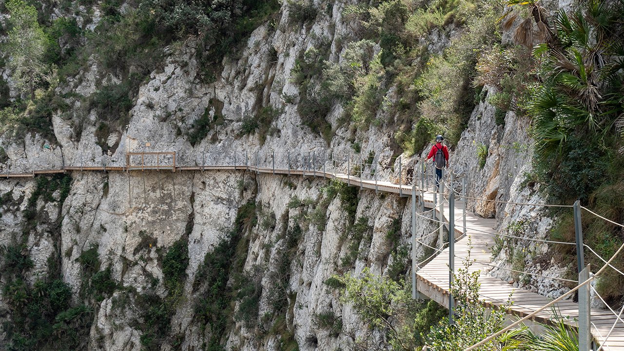 A man walking through the Relleu footbridge